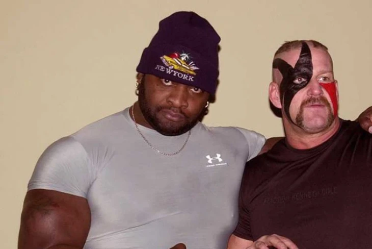 Ahmed Johnson net worth: Former WWE star flexing muscles, symbolizing his financial strength and wrestling legacy.