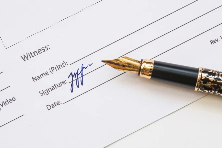 A document with a signature and a fountain pen, highlighting the transition from traditional to secure and fast e-signatures.